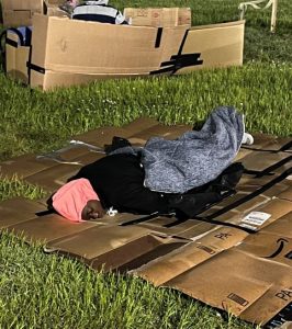 Person sleeping on a cardboard box